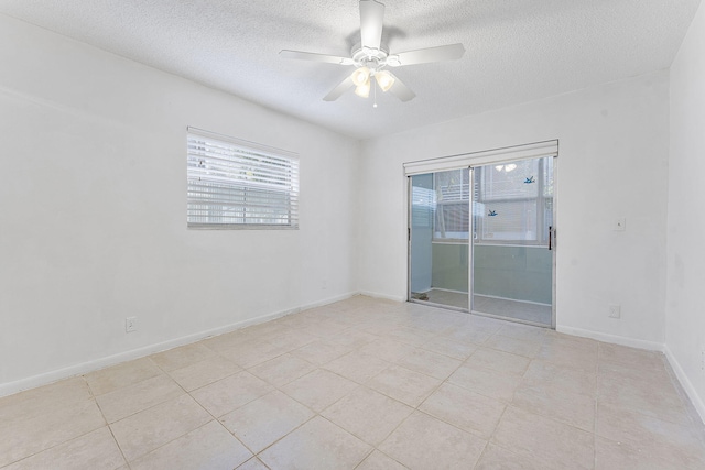 empty room featuring light tile patterned flooring, ceiling fan, and a textured ceiling