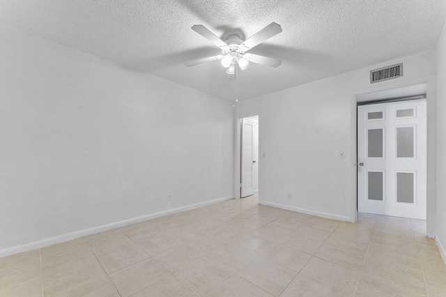 spare room featuring light tile patterned flooring, ceiling fan, and a textured ceiling