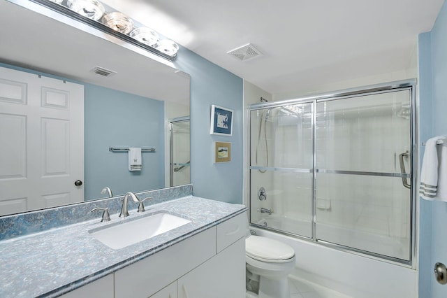 full bathroom featuring vanity, combined bath / shower with glass door, tile patterned floors, and toilet