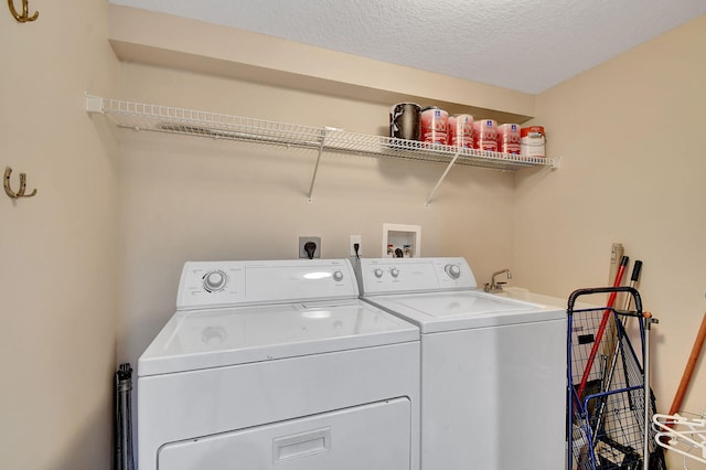 laundry room featuring separate washer and dryer and a textured ceiling