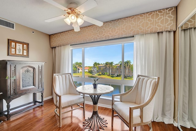 living area featuring hardwood / wood-style floors and ceiling fan