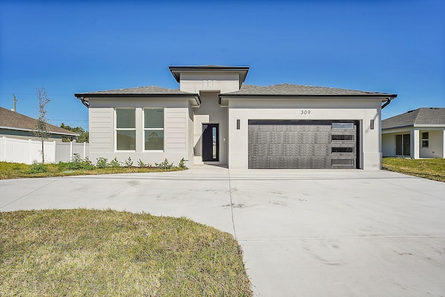 prairie-style home featuring a garage and a front yard