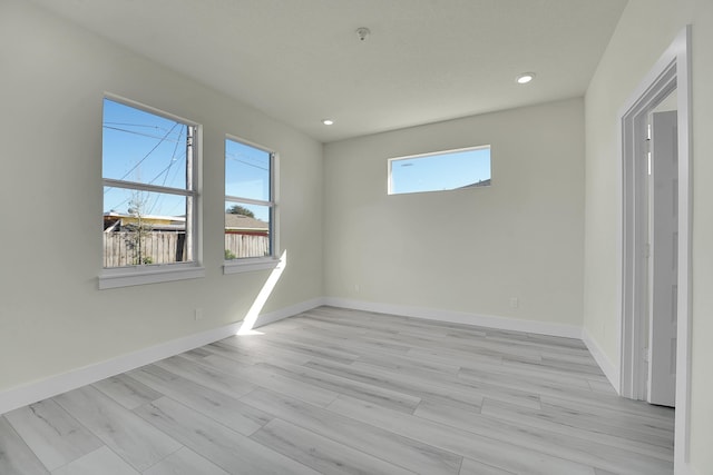 empty room featuring a healthy amount of sunlight and light hardwood / wood-style flooring