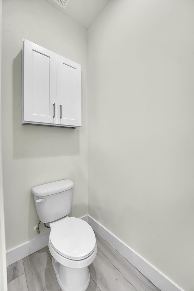 bathroom with hardwood / wood-style floors and toilet