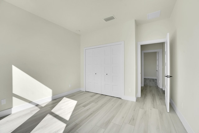 unfurnished bedroom with light hardwood / wood-style floors and a closet