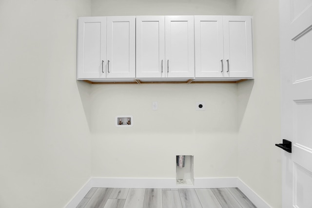 clothes washing area featuring cabinets, washer hookup, hookup for an electric dryer, and light hardwood / wood-style flooring