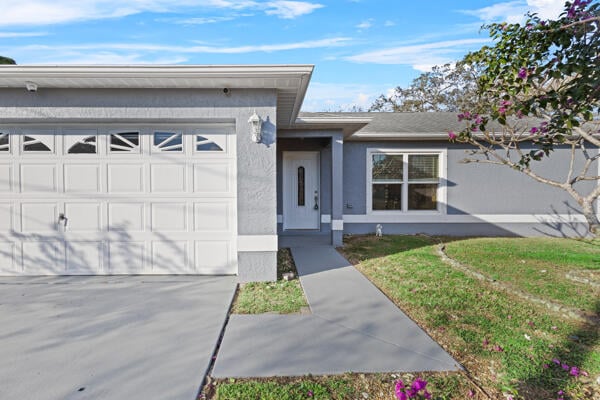 ranch-style house with a garage and a front yard