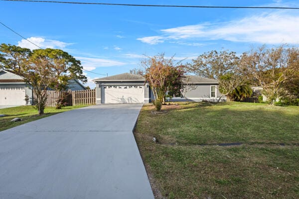 single story home featuring a garage and a front lawn