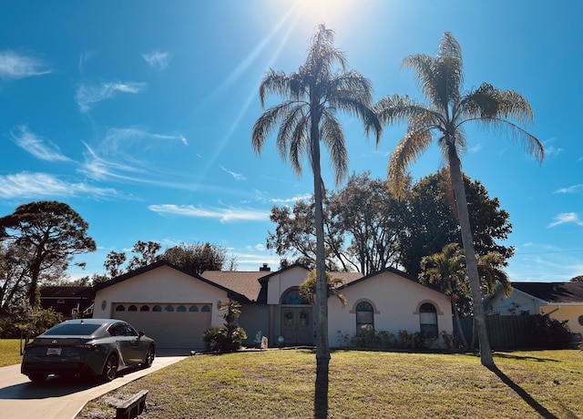 ranch-style house featuring a garage and a front lawn