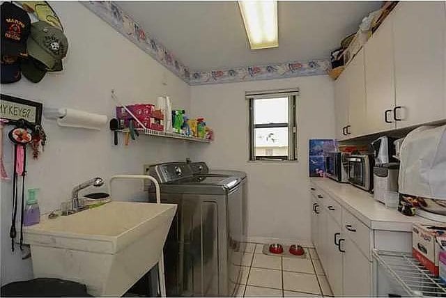 washroom featuring cabinets, separate washer and dryer, sink, and light tile patterned floors