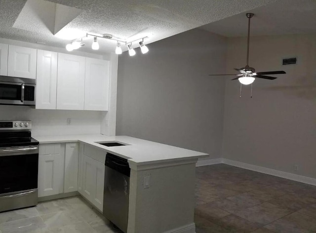 kitchen with white cabinetry, stainless steel appliances, kitchen peninsula, and a textured ceiling