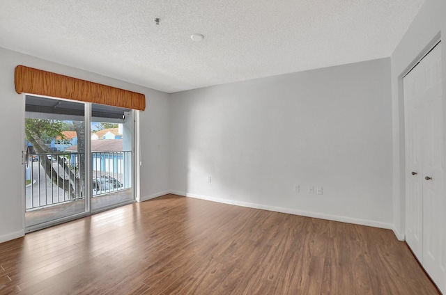 empty room featuring hardwood / wood-style floors and a textured ceiling