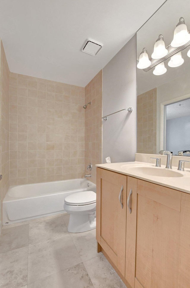 full bathroom with vanity, tile patterned flooring, tiled shower / bath combo, and toilet