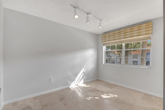 unfurnished room featuring a textured ceiling