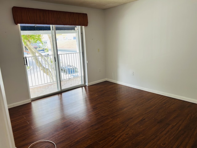 unfurnished room with dark hardwood / wood-style flooring