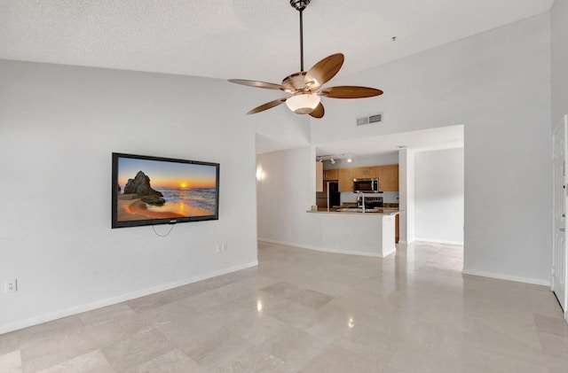 living room featuring high vaulted ceiling, sink, a textured ceiling, and ceiling fan