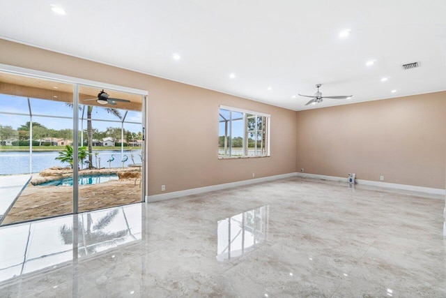 empty room featuring a water view and ceiling fan