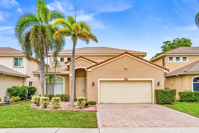 mediterranean / spanish-style house featuring a garage and a front yard