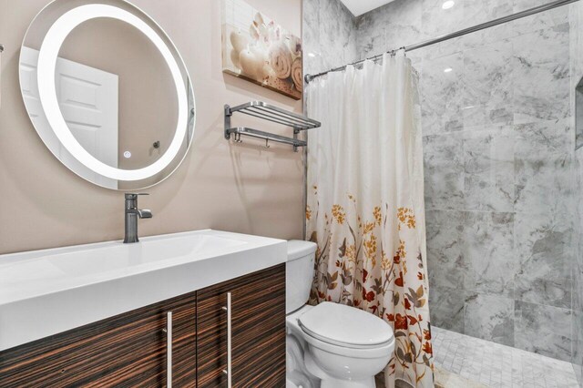 bathroom featuring vanity, toilet, and curtained shower