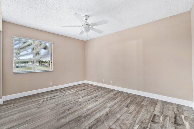 empty room featuring ceiling fan, a textured ceiling, and light hardwood / wood-style floors