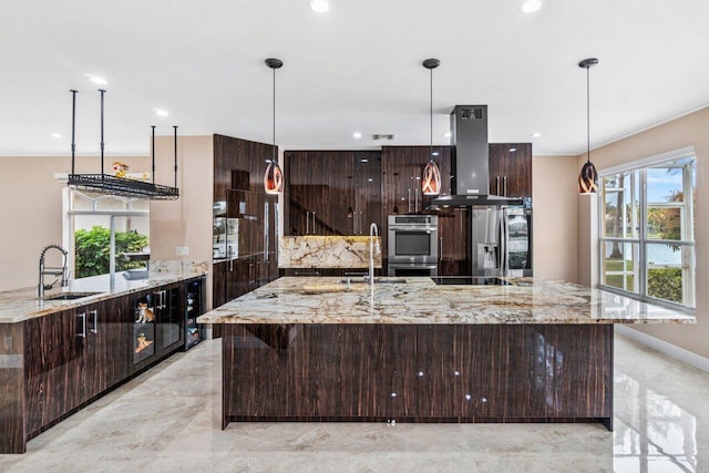 kitchen with light stone counters, island range hood, and decorative light fixtures