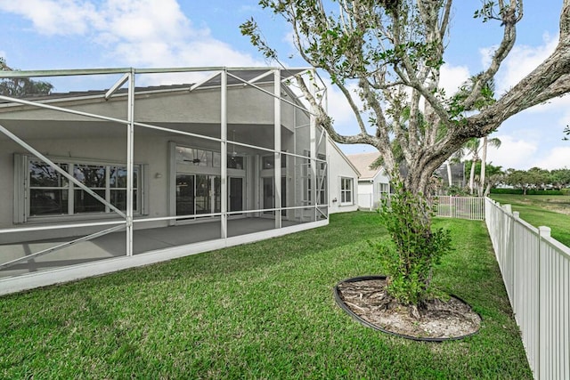 rear view of property featuring a yard and glass enclosure