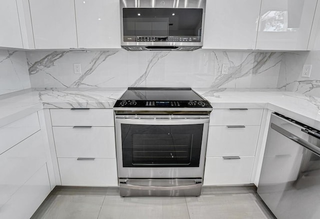 kitchen with light stone counters, appliances with stainless steel finishes, decorative backsplash, and white cabinets