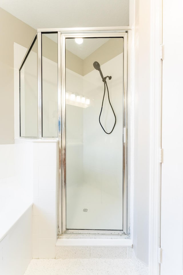 bathroom with a bath and a stall shower
