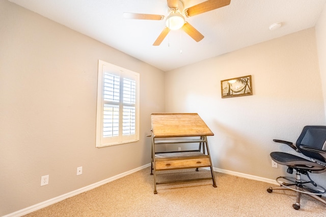 carpeted home office featuring baseboards and ceiling fan