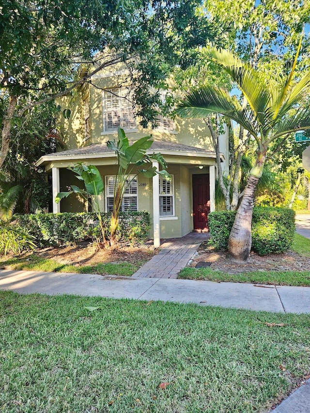 view of front facade with stucco siding and a front lawn