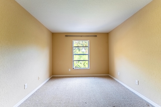 unfurnished room featuring a textured ceiling and carpet