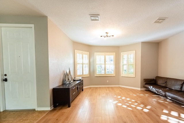 interior space with light hardwood / wood-style flooring and a textured ceiling