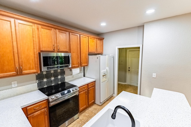 kitchen featuring a sink, recessed lighting, brown cabinets, and appliances with stainless steel finishes