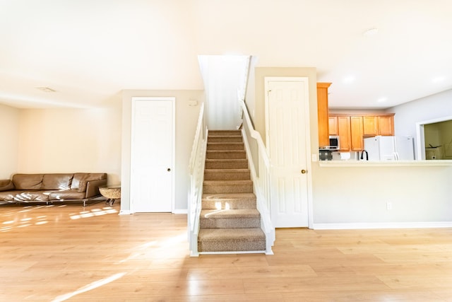 stairway with baseboards and wood finished floors