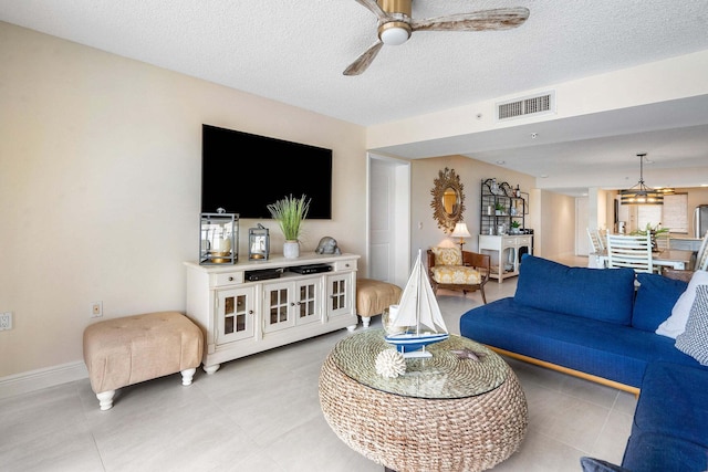 living room with ceiling fan and a textured ceiling