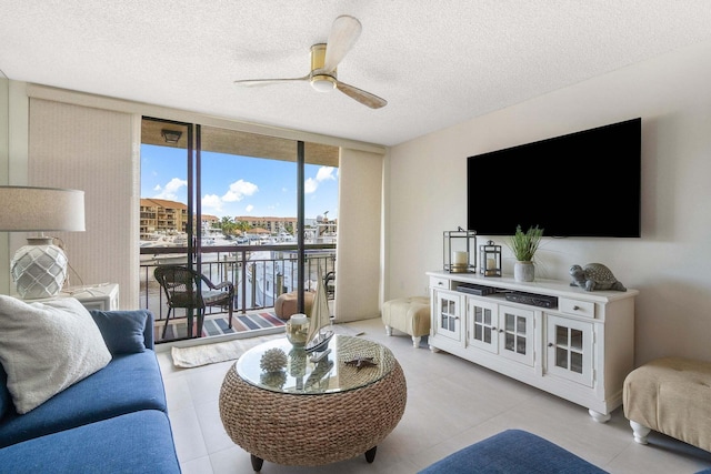 living room featuring floor to ceiling windows, ceiling fan, and a textured ceiling