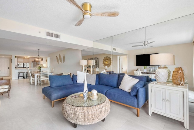 living room featuring a textured ceiling and ceiling fan