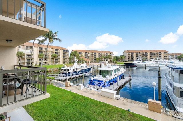 view of dock with a water view and a yard