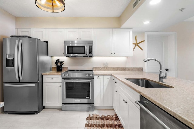 kitchen with white cabinetry, appliances with stainless steel finishes, sink, and light tile patterned flooring