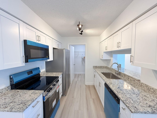 kitchen featuring light stone countertops, appliances with stainless steel finishes, sink, and white cabinets