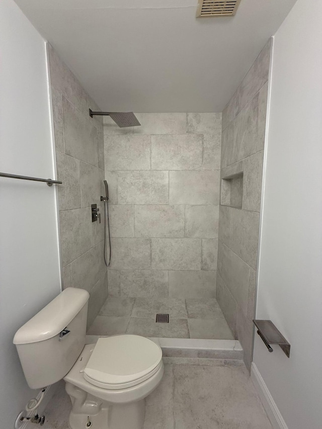 bathroom with toilet and tiled shower