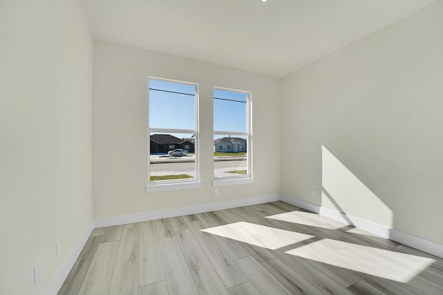 spare room with a wealth of natural light and light hardwood / wood-style floors