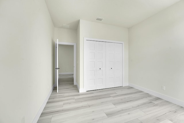 unfurnished bedroom with light hardwood / wood-style floors and a closet