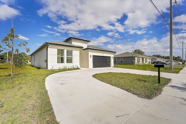 view of front of home with a garage and a front lawn