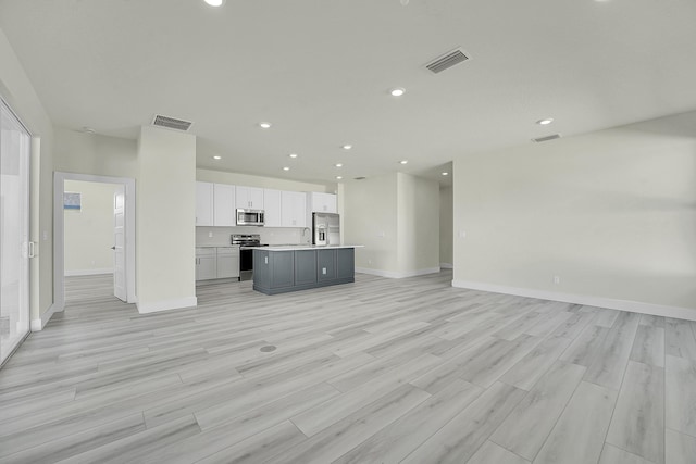 unfurnished living room with sink and light hardwood / wood-style flooring