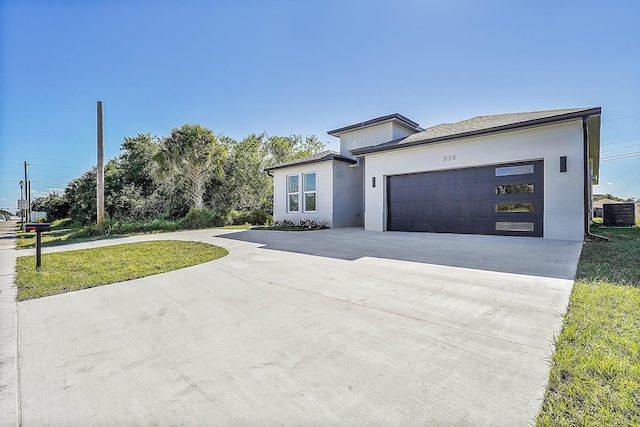 view of front of house featuring a garage, central AC, and a front yard