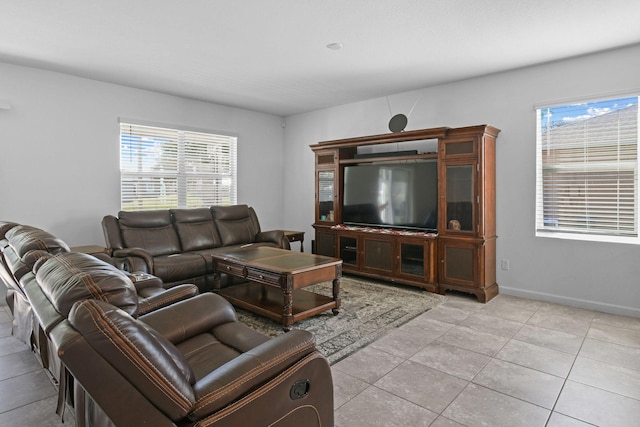 living area featuring baseboards, a wealth of natural light, and light tile patterned flooring