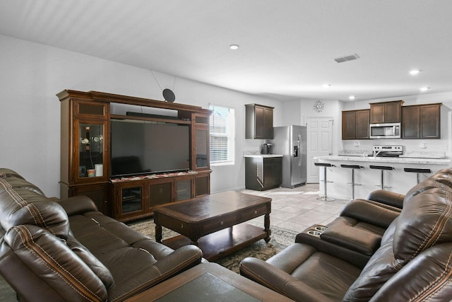 living room featuring light tile patterned floors, visible vents, and recessed lighting