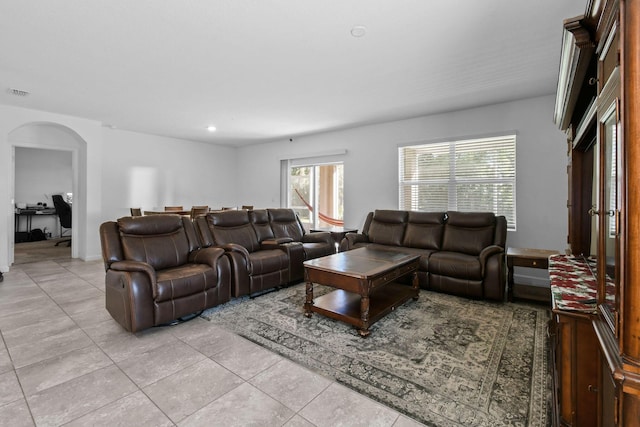 living area with arched walkways, light tile patterned floors, visible vents, and recessed lighting