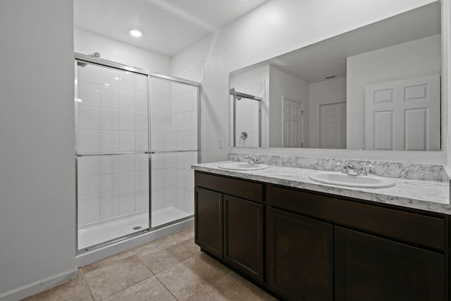 bathroom featuring double vanity, a shower stall, and a sink